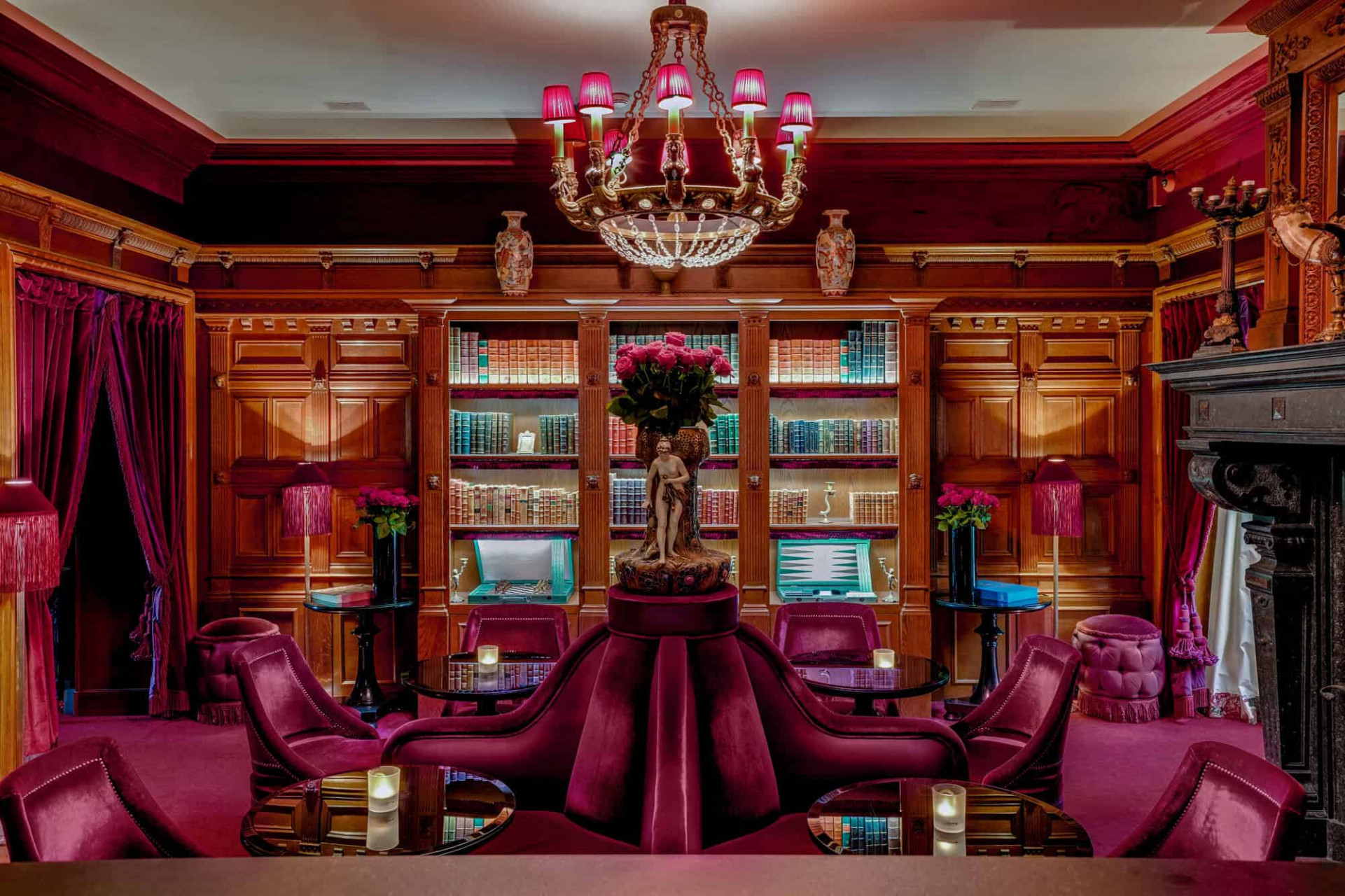Salón en el hotel Maison Souquet en Montmatre con tonos rosas sofás de terciopelo y un candelabro. 